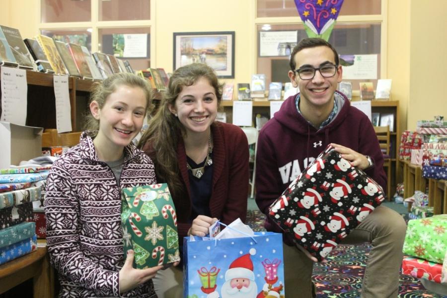 Seniors Marissa Donohue, Rebecca Houston, and Sam Weiner hold some of the gifts they helped wrap