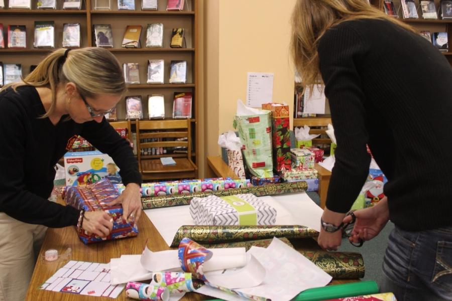 Teachers assisting in wrapping gifts