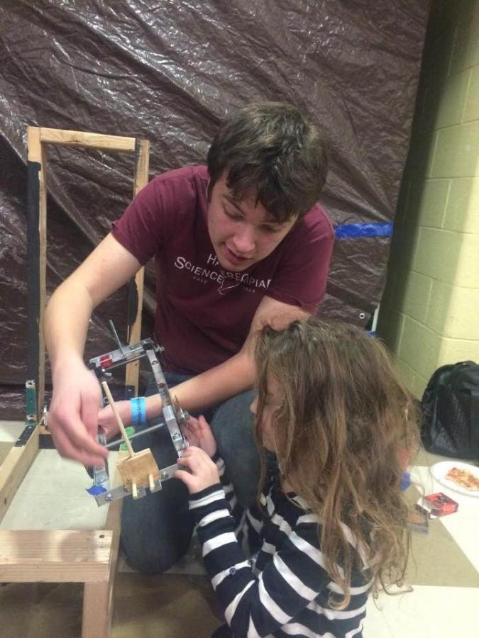 Senior Diego Fierros and his younger sister make final adjustments to his Scrambler: a device that must stop itself before hitting a wall and breaking an egg attached to its front. The Scrambler won 4th place in this weekends Conestoga Invitational.