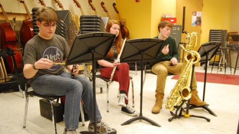 Stopping to mark music, the woodwinds of the pit band are (from left to right) Junior Aaron Mittleman on clarinet, Sophomore Liz Marino on flute, and Junior Stephen Lang on Tenor and Baritone  Saxophone. 
