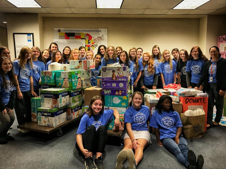 Pictured sitting (from left to right) are the Diaper Dry’ve officers Anabel Keagy, Abigail Wright, and Jade May. Surrounding them are the sponsor Tricia Dyal, and the members preparing for the “Stuff the Bus” campaign. 