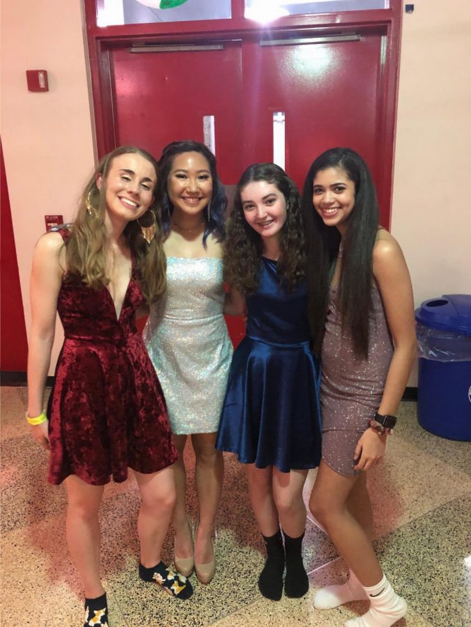 Attending the Homecoming Dance, Sophia Carr, Seryna Chung, Kiera Dowdell, and Taylor Pickering take a break from dancing to mingle in the lobby. 