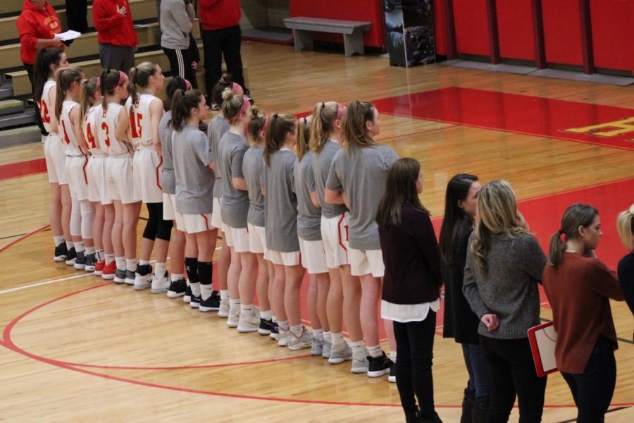 The Lady Fords line up during the pre-game singing of the National Anthem. 