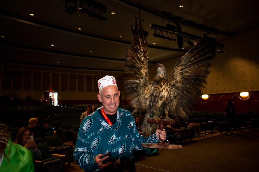 Principal Pete Donaghy dons an Eagles onesie and holds a taxidermist eagle aloft before the Wing Bowl. 