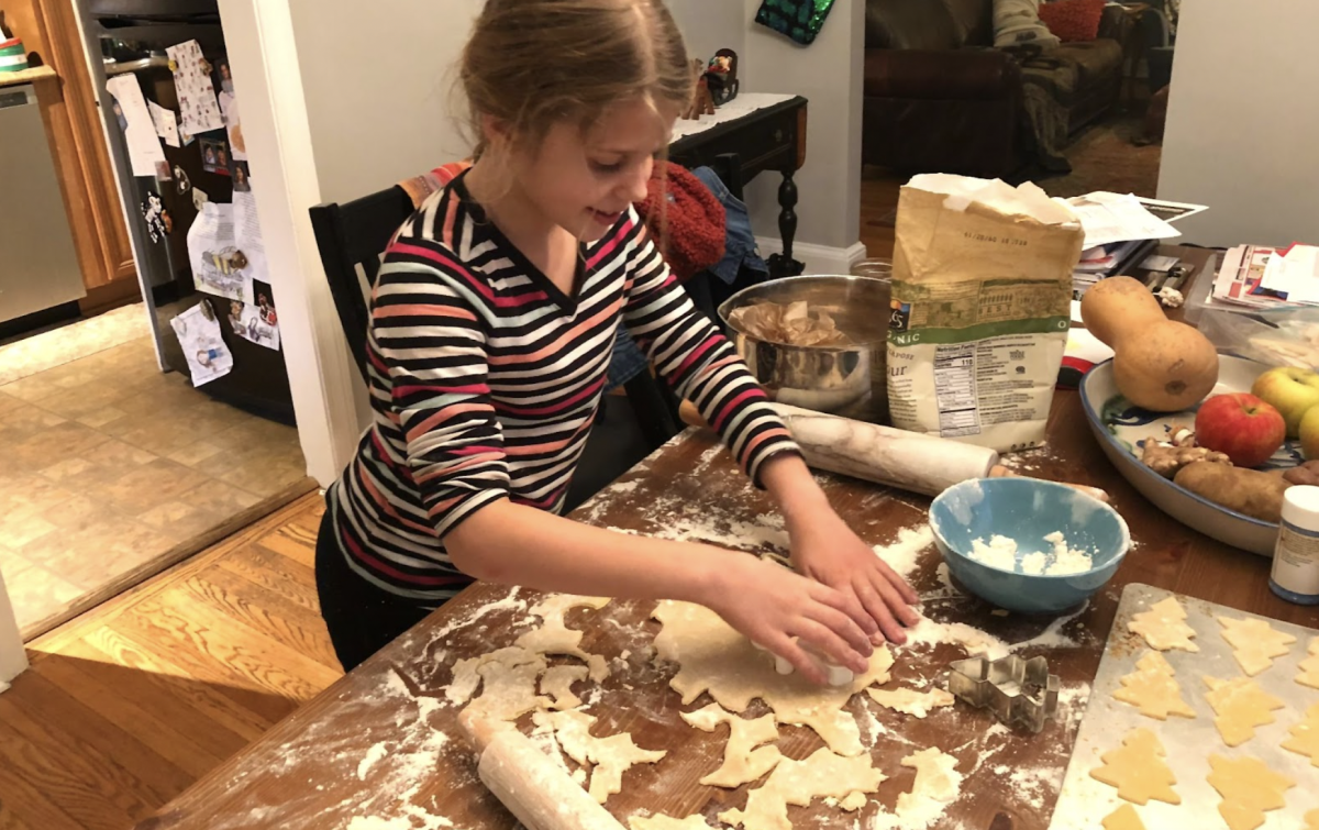 Myself as a child as photographed by my mother, cutting tree-shaped butter cookies from our family recipe. 